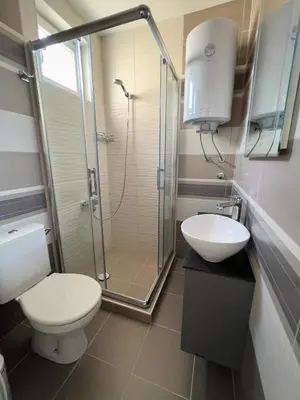 a bathroom with a shower and a toilet and a sink at Hany Sweet in Niš