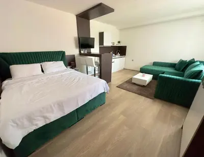a bedroom with a large bed and a couch at Hany Sweet in Niš
