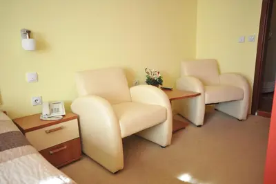 a hospital room with two chairs and a phone at Medijana Apartments Niš in Niš
