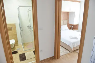 a bathroom with a shower and a bed in a room at Apartmani Martenovic in Vrnjačka Banja