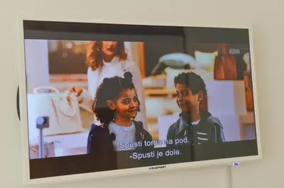 a television with a picture of two children on it at Apartmani Martenovic in Vrnjačka Banja