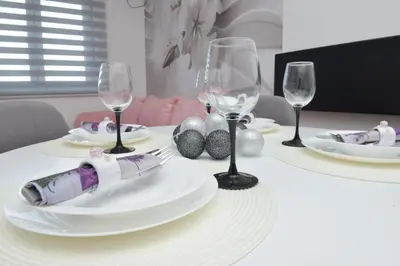 a table with white plates and wine glasses on it at Apartmani Martenovic in Vrnjačka Banja