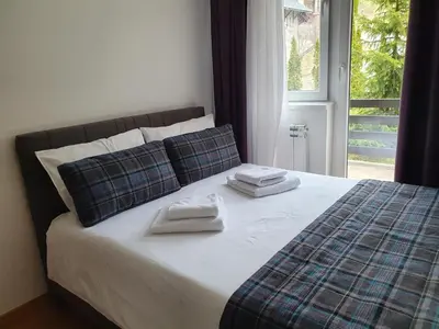 a bed with two towels on it with a window at PLANINSKO JUTRO - Brzeće Centar Apartments, Kopaonik in Brzeće