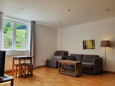 a living room with a couch and a table at PLANINSKO JUTRO - Brzeće Centar Apartments, Kopaonik in Brzeće