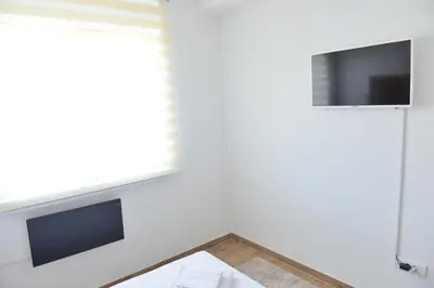 a living room with a tv and a table at Apartman Martenovic 2 in Vrnjačka Banja
