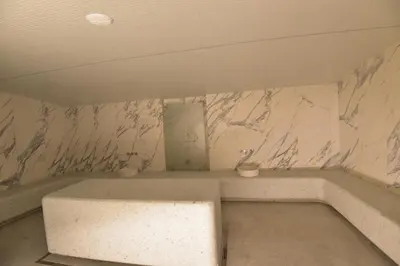 a bathroom with a white marble wall with a sink at Woodside Kopaonik Residences in Kopaonik