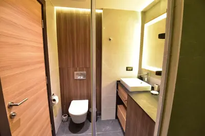 a bathroom with a toilet and a sink and a mirror at Woodside Kopaonik Residences in Kopaonik