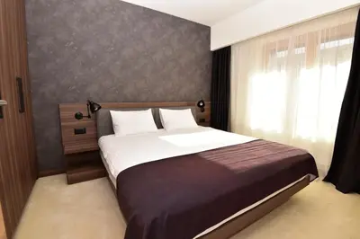 a bedroom with a large bed and a window at Woodside Kopaonik Residences in Kopaonik