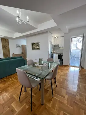 a dining room with a glass table and chairs at Apartman MIA Centar in Kruševac