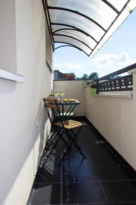 a small balcony with a table and chairs on it at Apartman MIA Centar in Kruševac