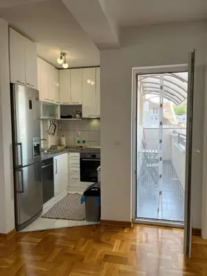 a kitchen with stainless steel appliances and a sliding glass door at Apartman MIA Centar in Kruševac