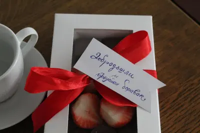 a greeting card with a red ribbon and a note at Apartman Bonaca in Vrnjačka Banja