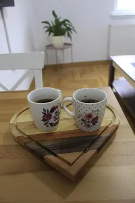 two cups of coffee sitting on a wooden tray at Apartman Bonaca in Vrnjačka Banja
