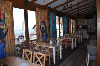 a restaurant with tables and chairs and large windows at NATURA LUX MILMARI k 12 in Kopaonik
