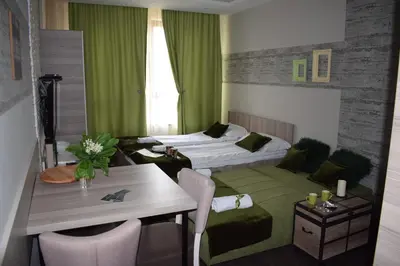a hotel room with a bed and a table and chairs at NATURA LUX MILMARI k 12 in Kopaonik