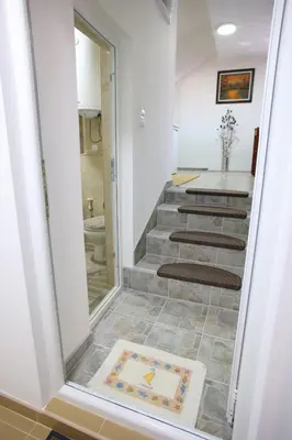 a bathroom with stairs with a mirror and a sink at Apartmani Đorđević in Soko Banja