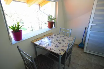 a table and chairs in a room with a window at Apartmani Đorđević in Soko Banja
