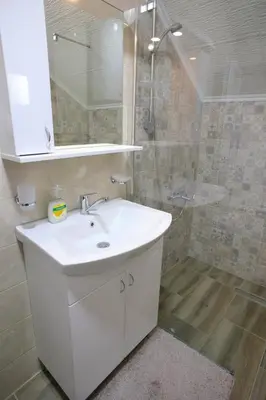a bathroom with a white sink and a shower at Apartmani Đorđević in Soko Banja