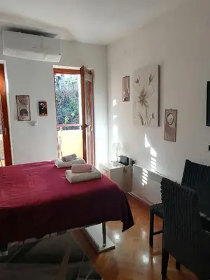 a bedroom with a red bed and a window at Apartman Lala in Vrnjačka Banja
