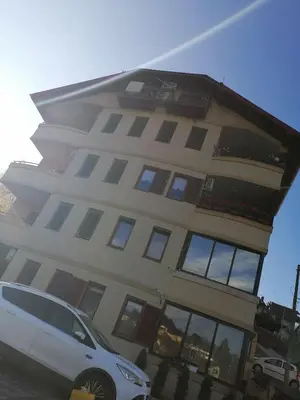 a white car parked in front of a building at Apartman Lala in Vrnjačka Banja