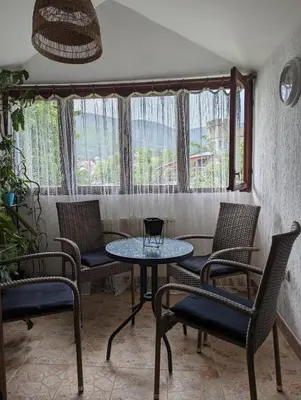 a table and chairs in a room with a window at Apartmani Trio in Soko Banja