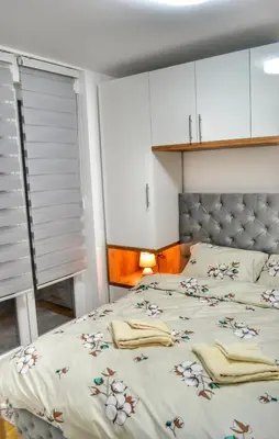 a bedroom with a large bed with white cabinets at Apartman Krila andjela in Vrnjačka Banja