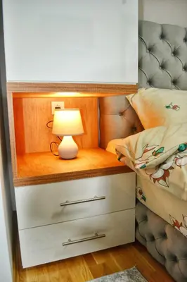 a bed room with a lamp on a night stand at Apartman Krila andjela in Vrnjačka Banja