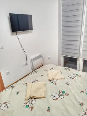 a bedroom with a bed with flowers on it at Apartman Krila andjela in Vrnjačka Banja