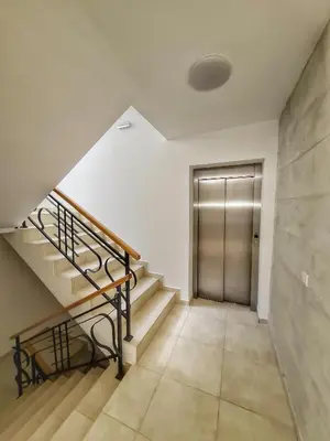 a hallway with stairs and a metal door at Apartman Krila andjela in Vrnjačka Banja