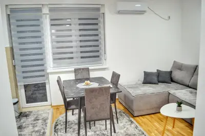 a living room with a table and chairs and a couch at Apartman Krila andjela in Vrnjačka Banja