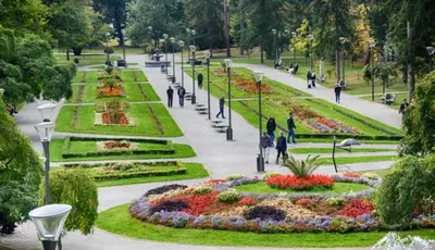 people walking in a park with flowers and lights at Apartmani Martenovic 1 in Vrnjačka Banja