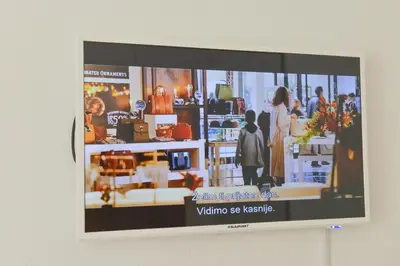 a television screen on a wall displaying a store at Apartmani Martenovic 1 in Vrnjačka Banja