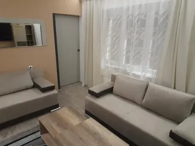 a living room with a couch and a table and a window at Aurora in Kruševac