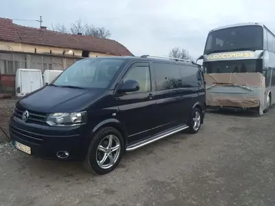 a black van parked next to a double decker bus at Aurora in Kruševac