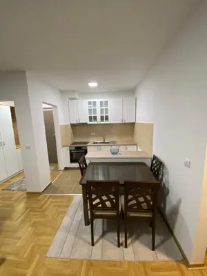a kitchen with a table and chairs in a room at Maya apartman sa dve spavace sobe in Vrnjačka Banja