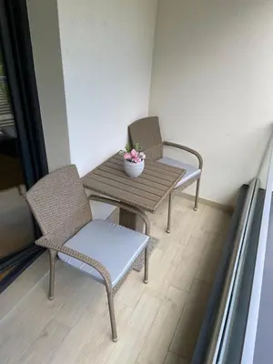 two chairs and a table in a room at Maya apartman sa dve spavace sobe in Vrnjačka Banja