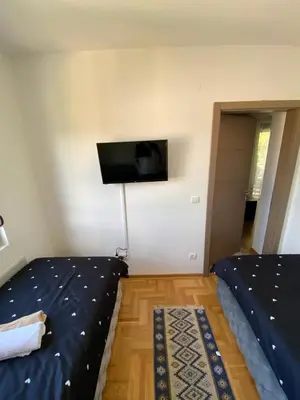 a bedroom with a bed and a flat screen tv on the wall at Maya apartman sa dve spavace sobe in Vrnjačka Banja
