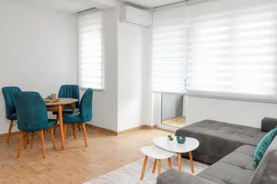 a living room with a couch and a table and chairs at Vuković Lux in Vrnjačka Banja