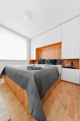 a bedroom with a large bed with a wooden headboard at Vuković Lux in Vrnjačka Banja