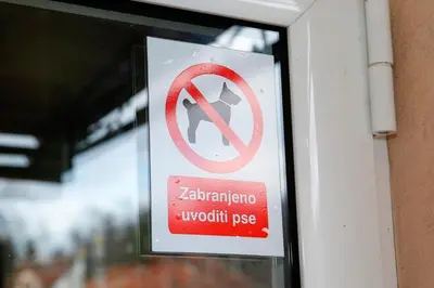 a sign in a window with a no smoking sign at Apartman Dunja in Vrnjačka Banja
