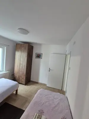 a bedroom with a bed and a refrigerator in it at Apartmani Petrović SEMČE Suva Planina in Gadžin Han