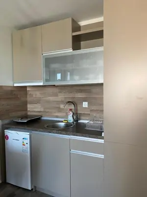 a kitchen with white cabinets and a sink and a refrigerator at Milmari Premier 28 Kopaonik in Kopaonik