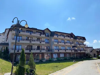 a large white building with windows and a street light at Milmari Premier 28 Kopaonik in Kopaonik