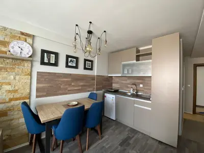 a kitchen with a wooden table and blue chairs at Milmari Premier 28 Kopaonik in Kopaonik