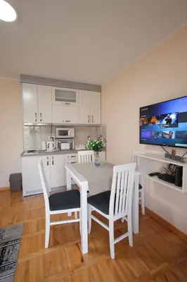 a kitchen with a table and chairs and a television at Vila Vrnjački Raj in Vrnjačka Banja