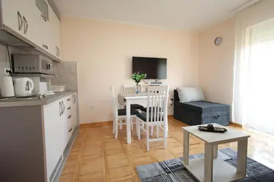 a kitchen and living room with a table and a couch at Vila Vrnjački Raj in Vrnjačka Banja