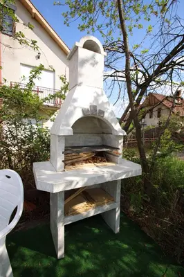 a stone oven in a yard with a house at Vila Vrnjački Raj in Vrnjačka Banja