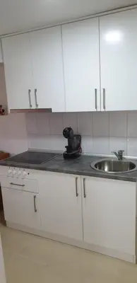 a kitchen with white cabinets and a sink at Apartman Djekovic in Jošanička Banja
