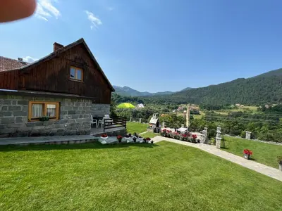 a house with a grassy yard next to a building at Apartman Djekovic in Jošanička Banja