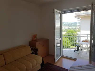 a living room with a couch and a sliding glass door at Kragić apartman in Soko Banja